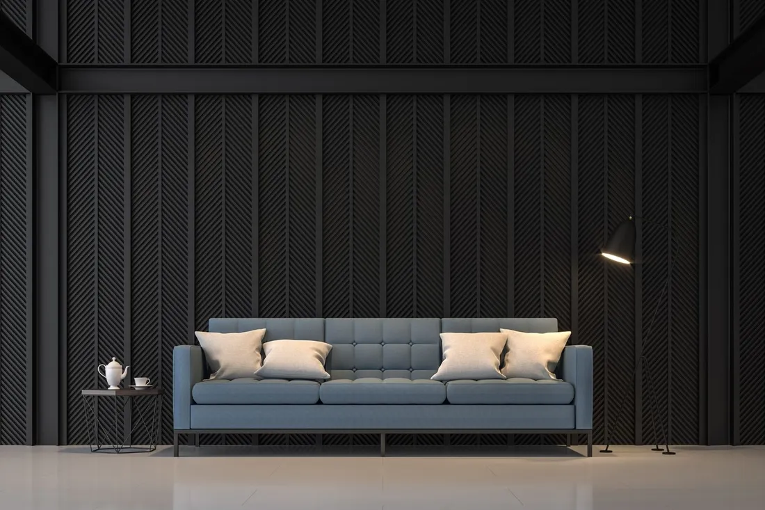 Niebieska pikowana sofa przy czarnej ścianie z ryflowanymi panelami